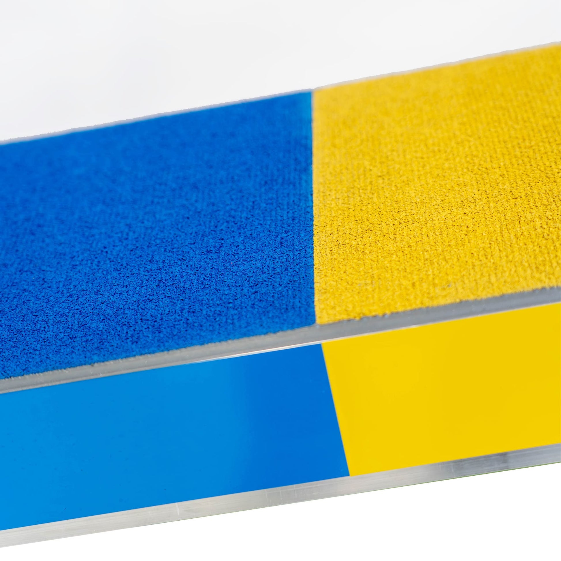 Close-up of yellow and blue anti-slip surface on Callieway agility seesaw